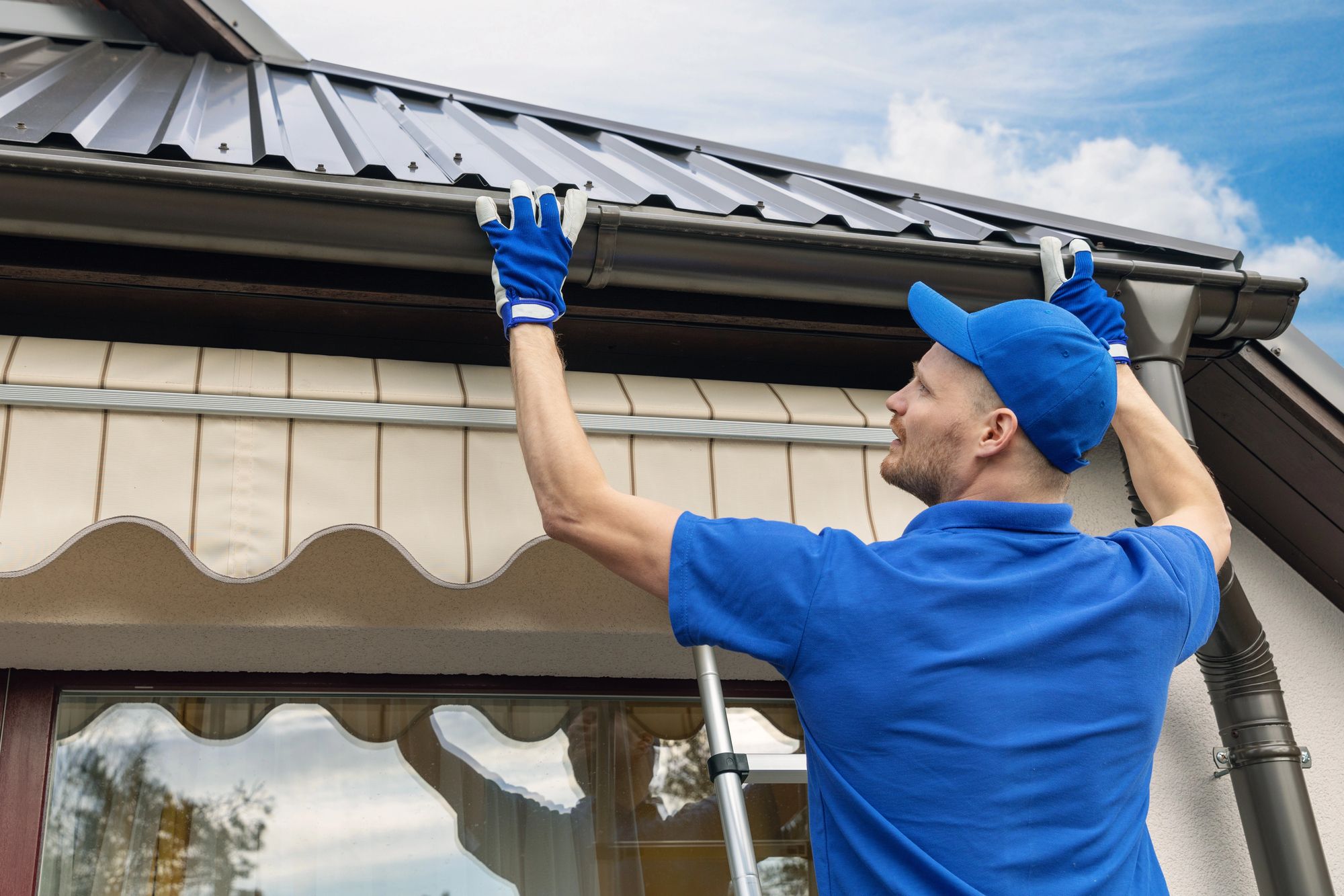 A Seamless NWA crew member installing a gutter